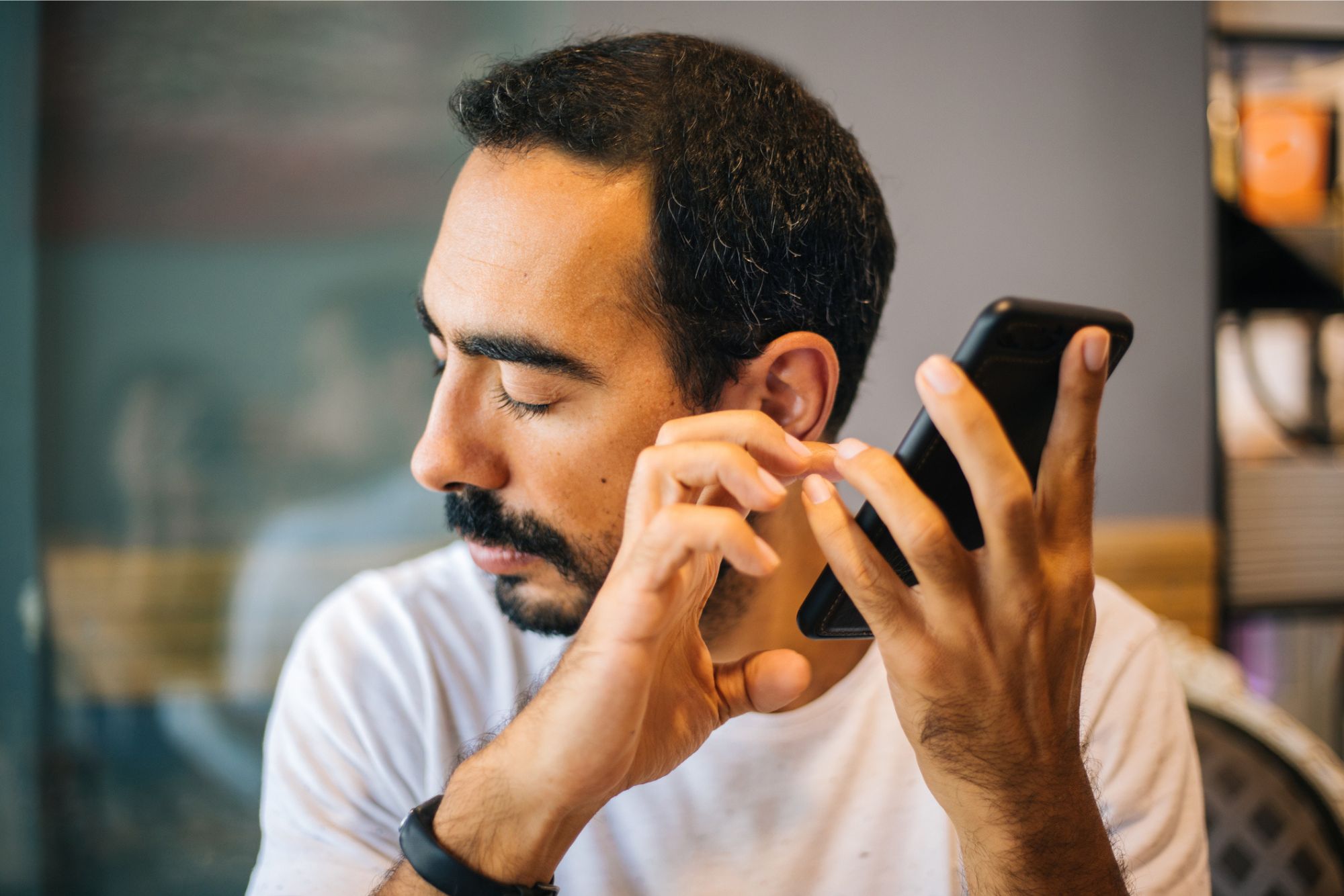 A blind man holds a phone to his ear as he uses voice control to navigate the CVS Health website.